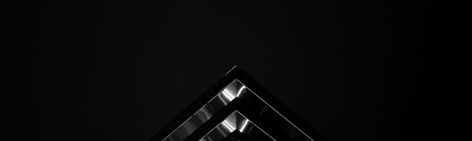 Representa uma arquitetura cívil moderna na cor prata em um fundo preto