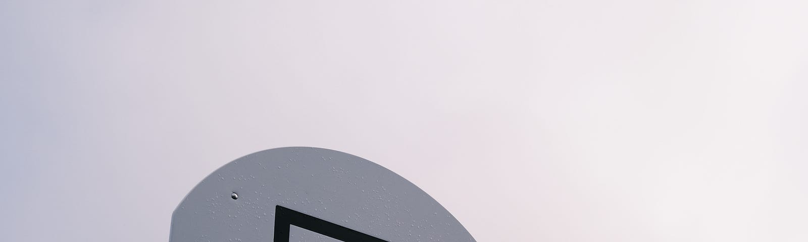 A black and white basketball rim with a chain net, sitting on a backdrop of clouds and smoke