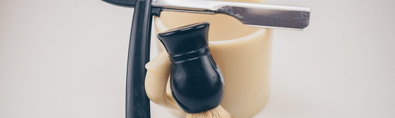 An image of a shaving brush and a shaving knife, barber style.