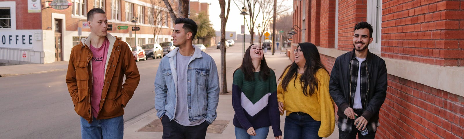 Image of young people walking along a street laughing