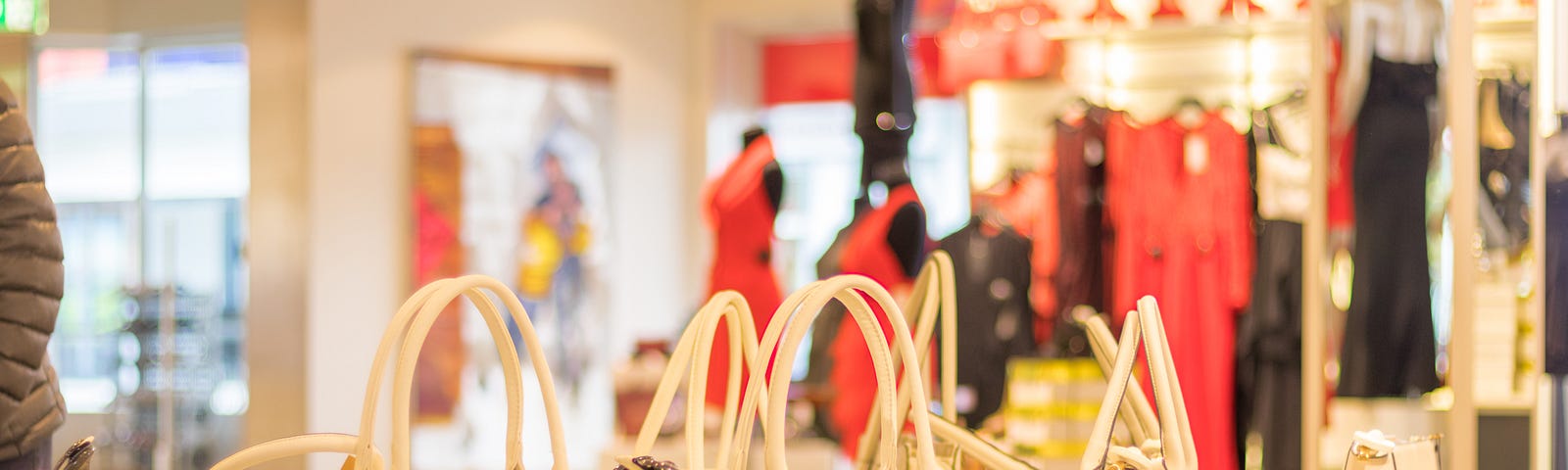 Display of off-white handbags in what looks like a department store