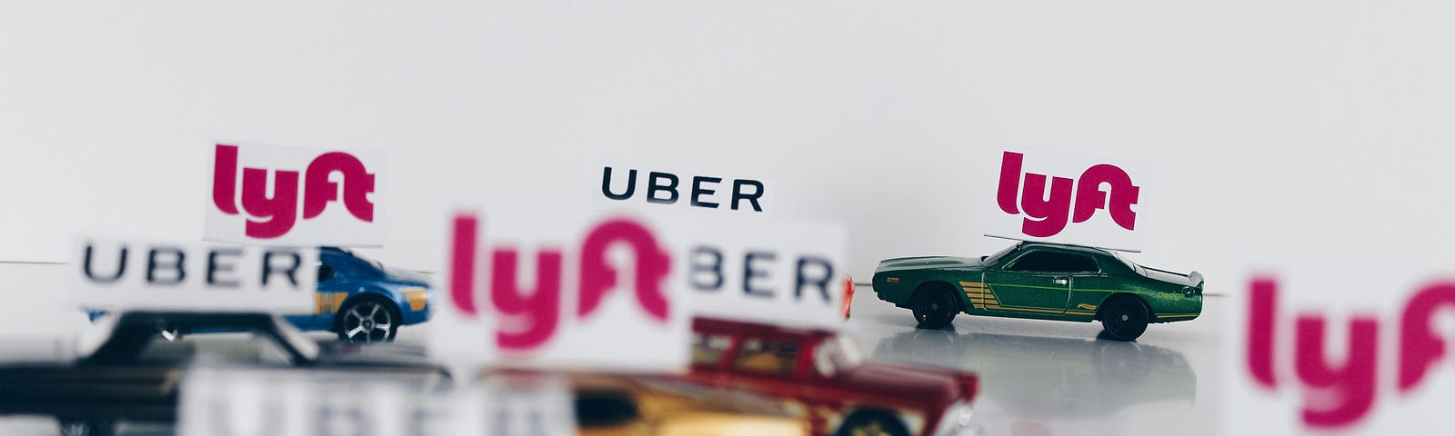 A picture of multiple model cars labeled Uber or lyft