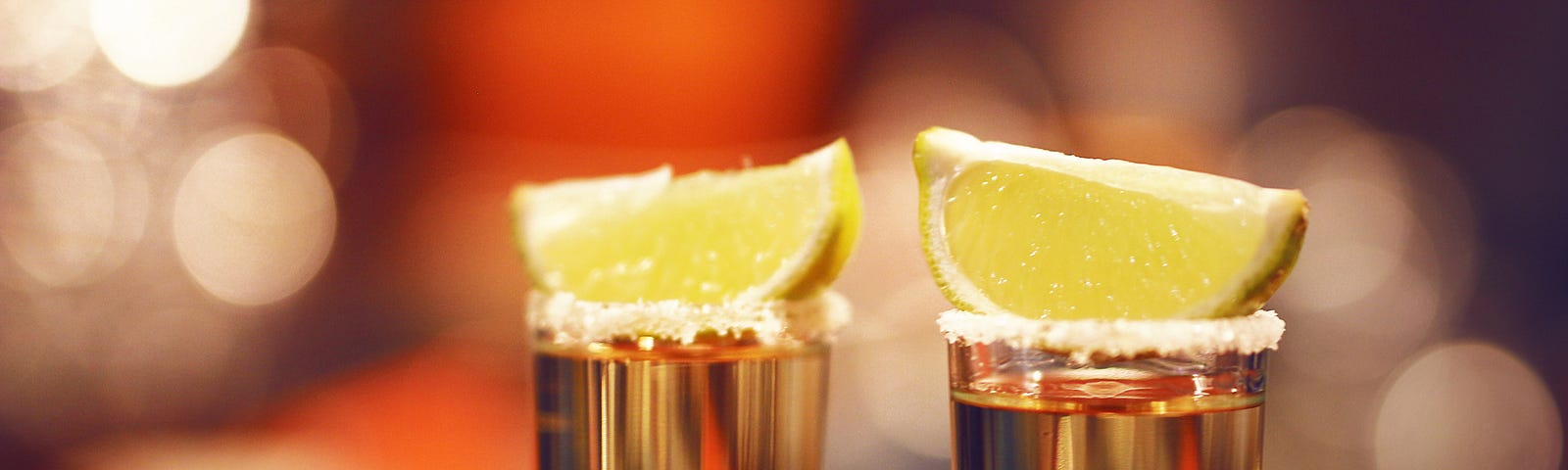Two lemon slices on two copper shot glasses, lemon wedges on top!