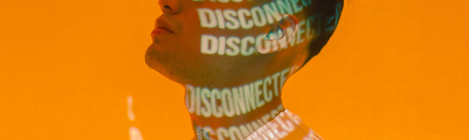 Picture of a man with the word “disconnected” projected numerous times on his body.