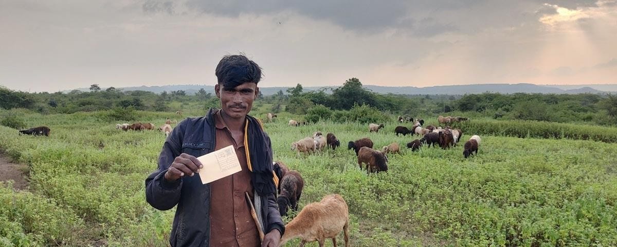 A pastoralist young man displaying the postcard that he mailed to the Chief Minister.