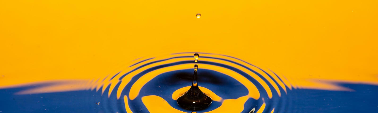 A ripple of water cast in blue and yellow colours of light.