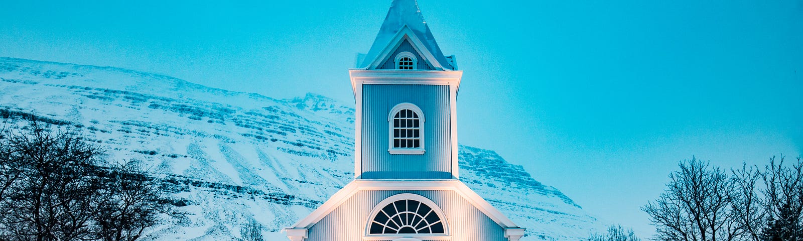 A white church building amidst a snowy backdrop.