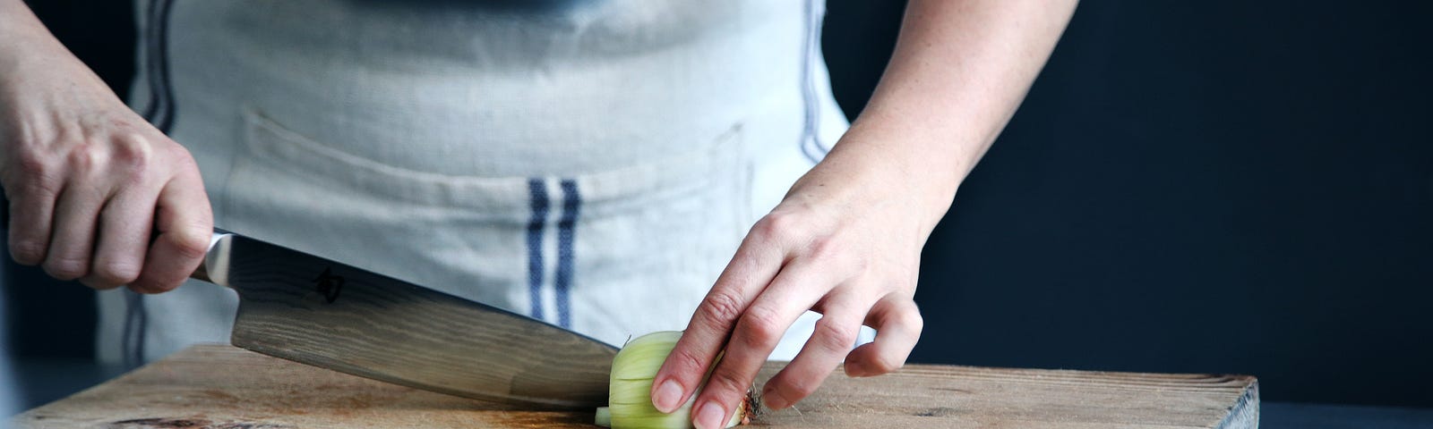 woman chopping onions on a cutting board