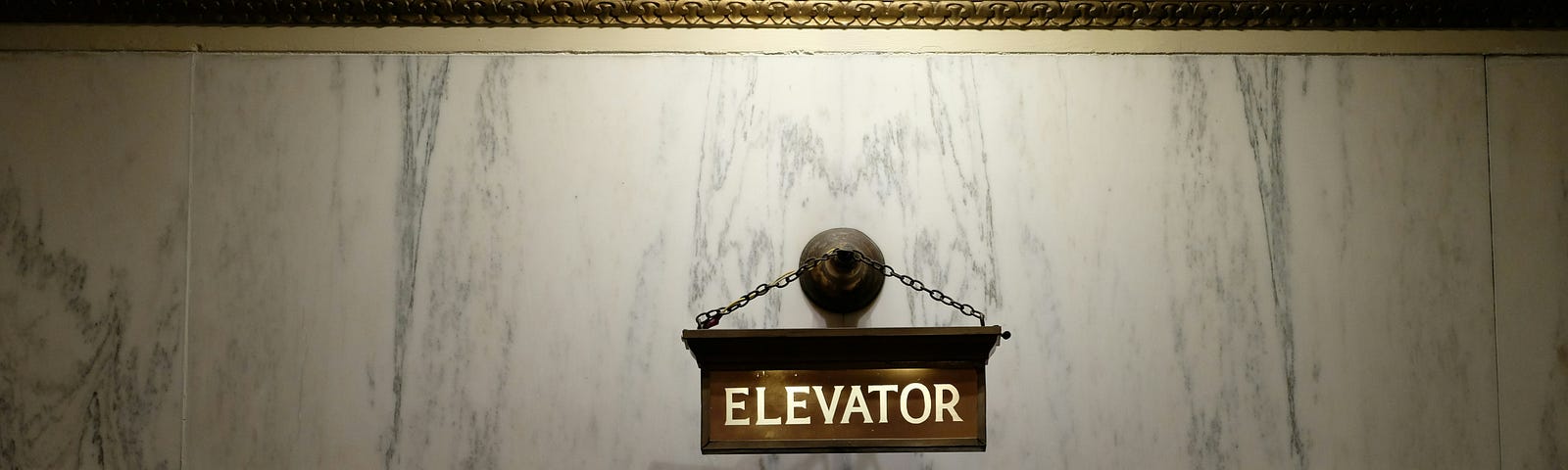 Photo of an elevator with a single dim light overhead.