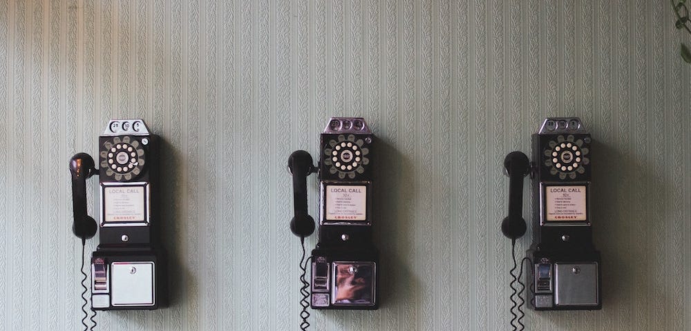 An image of rotary pay phones mounted on a wall