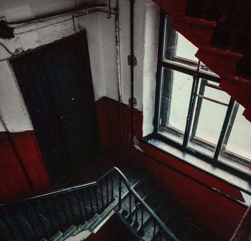 A staircase in a run down looking apartment building