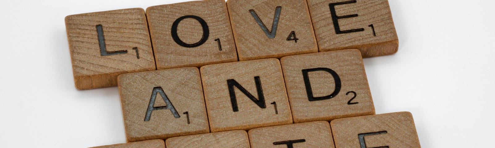 The words “Love and Hate” are spelled out using Scrabble tiles.