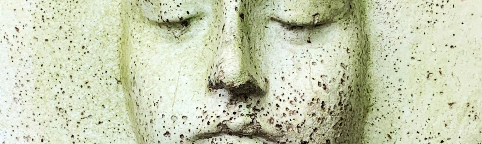 An expression-less face carved from stone