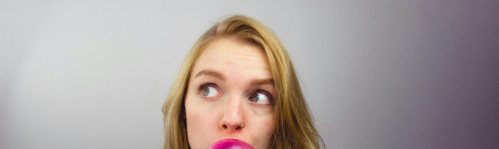 a woman blowing a bubble gum bubble