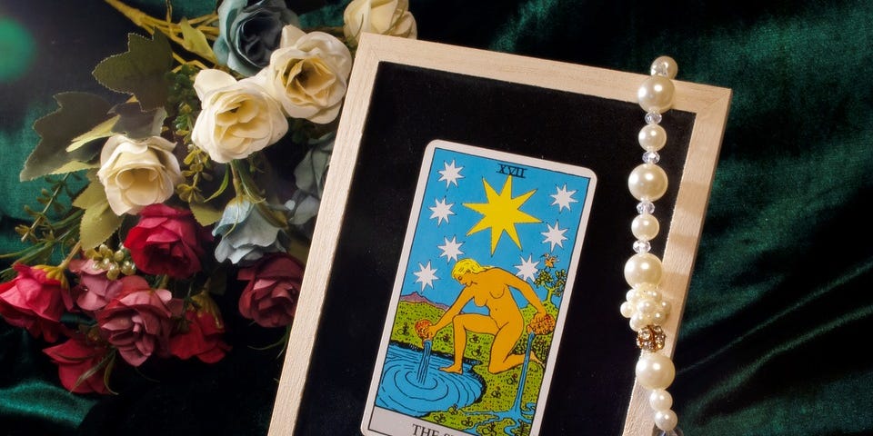 The Star Tarot Card, showing a naked woman, her knee on the shore, her foot in the pond.