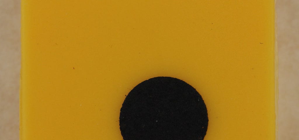 A large yellow square with a black comma near the bottom middle.