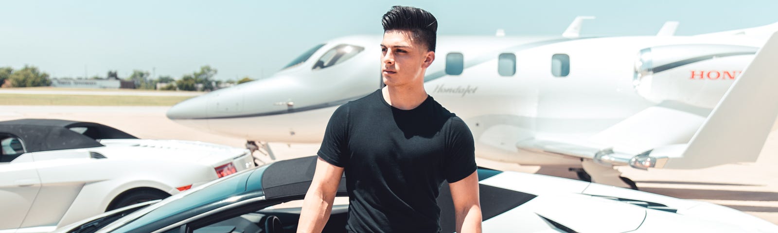 Young man getting out of expensive sports car next to private jet.