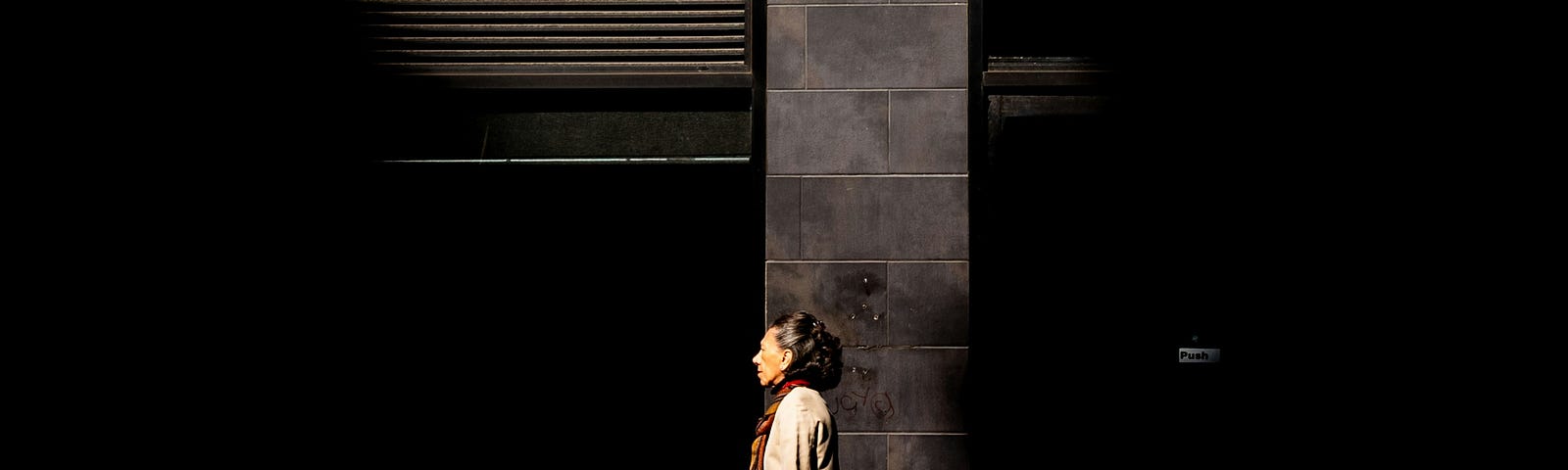 Individual people, captured as they walk into a shaft of light on Broadway in New York.
