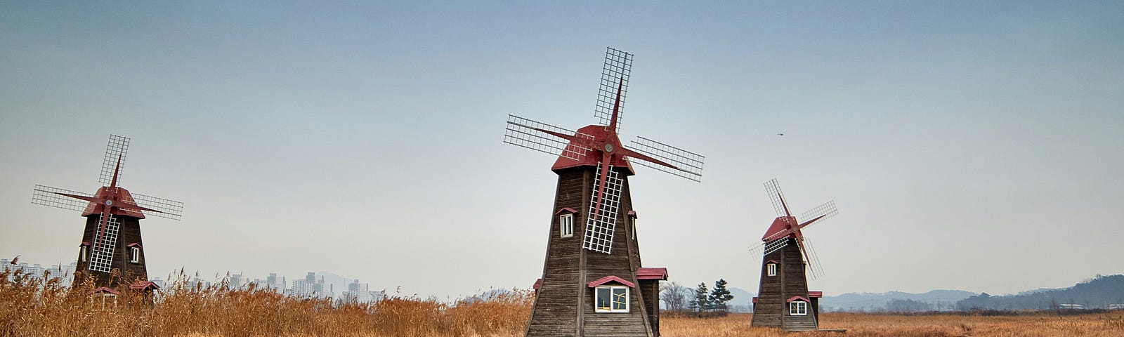 Three windmills in a field.