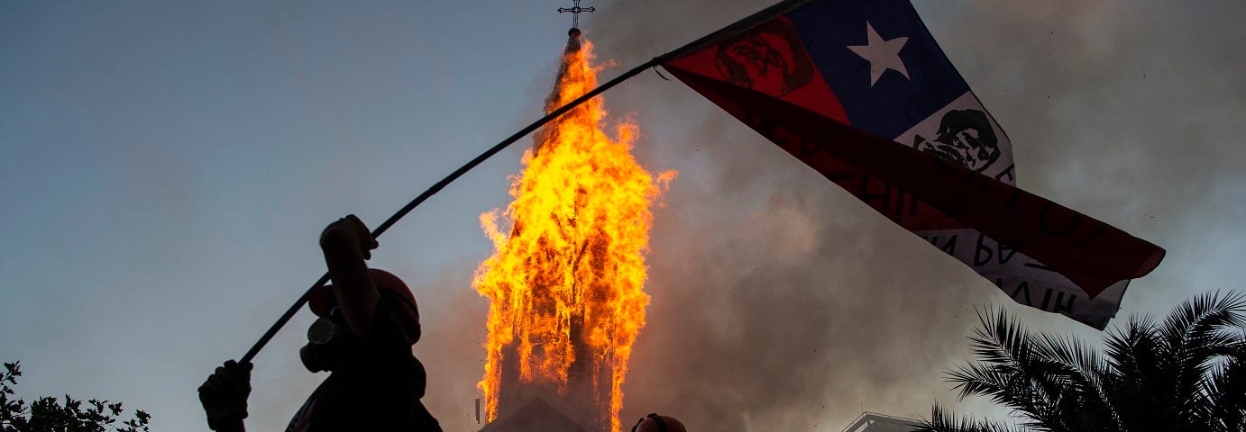 Igreja de Assunção sendo incendiada no Chile e manifestantes comemorando.