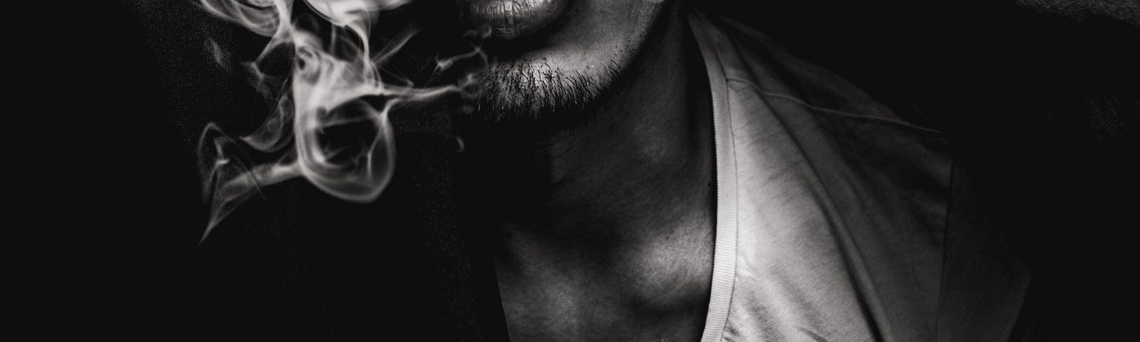 closeup of man in tank top with smoke coming out of his mouth