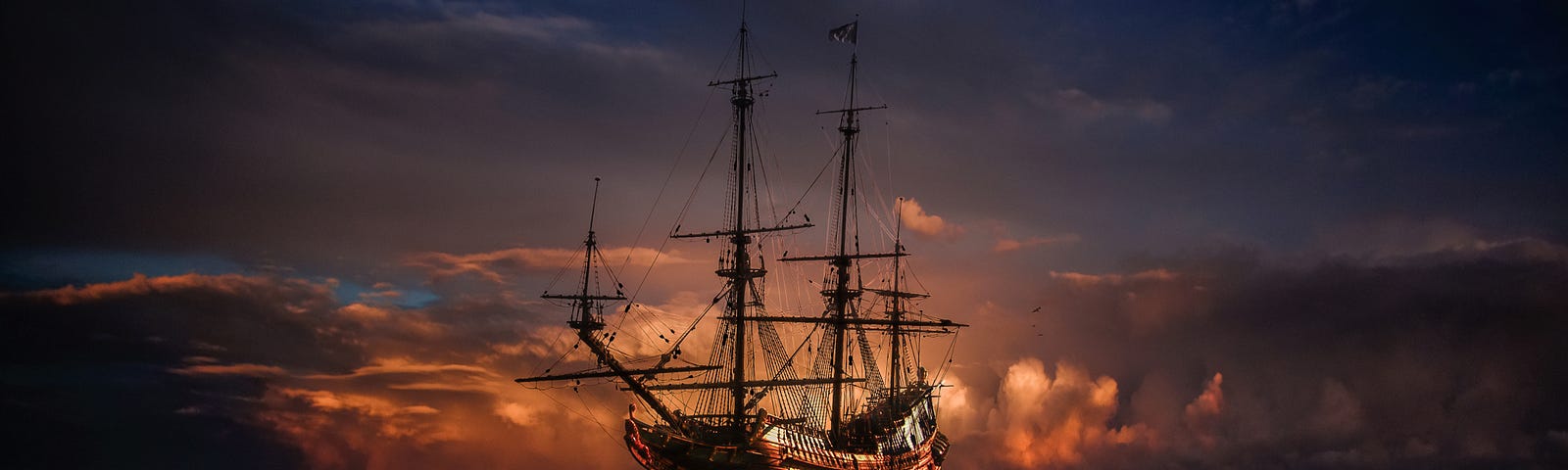 A pirate ship sailing the high seas at sunset.