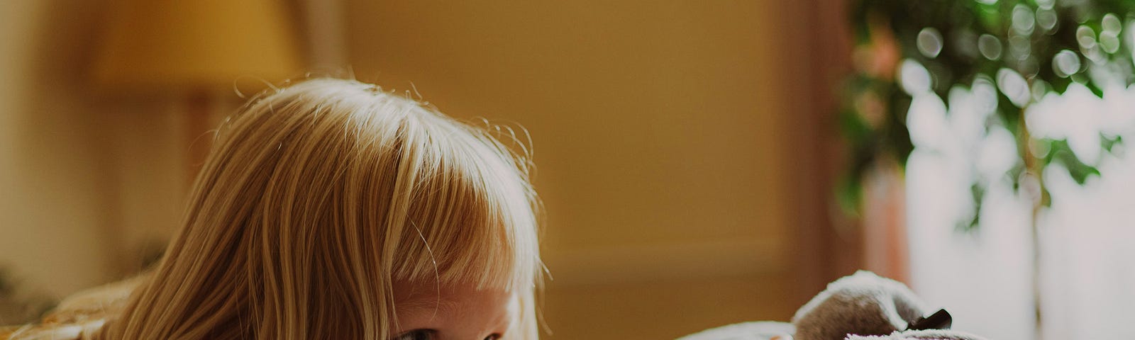 young girl peeking from behind a couch