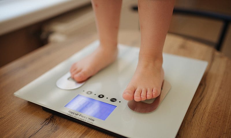 A child checking her weight