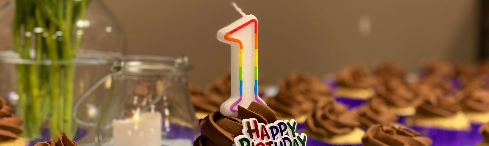 A table of birthday cupcakes, one of which has a ‘1’ candle and ‘Happy birthday’ decoration