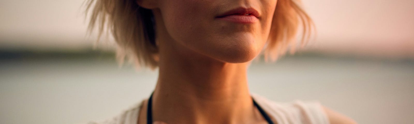 Woman in workout clothes with hand on chest and eyes closed.