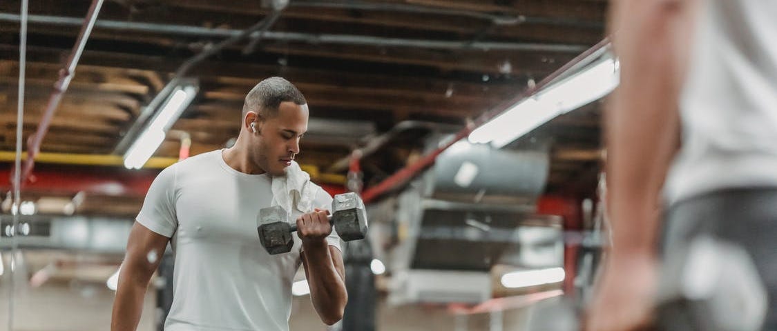 Man doing a bicep curl in front of the mirror