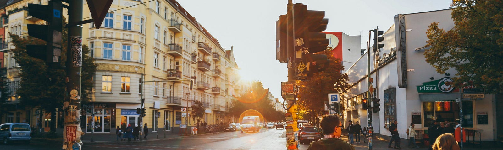 people standing at an intersection with little daylight