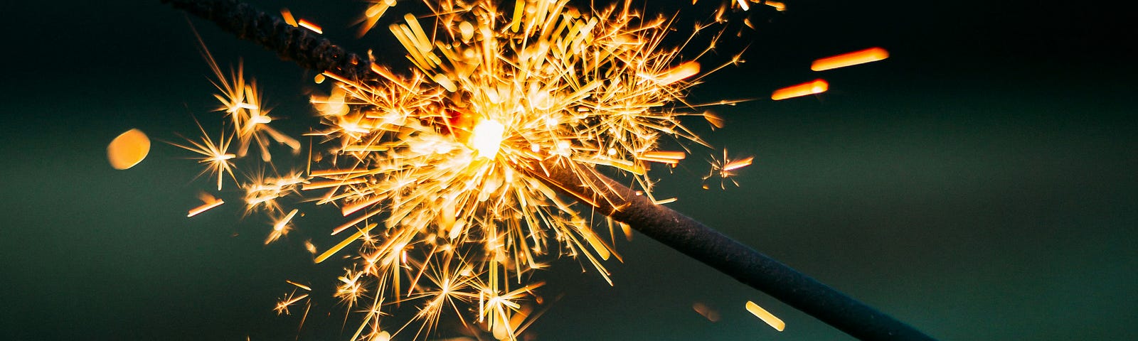 Two lit sparklers touch each other