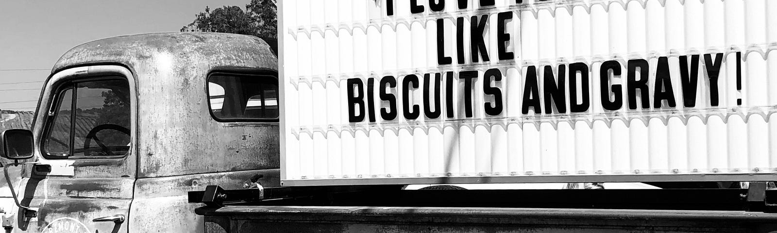 Pickup truck with flashing arrow sign in the bed of it. Saying on sign — I love you like biscuits and gravy