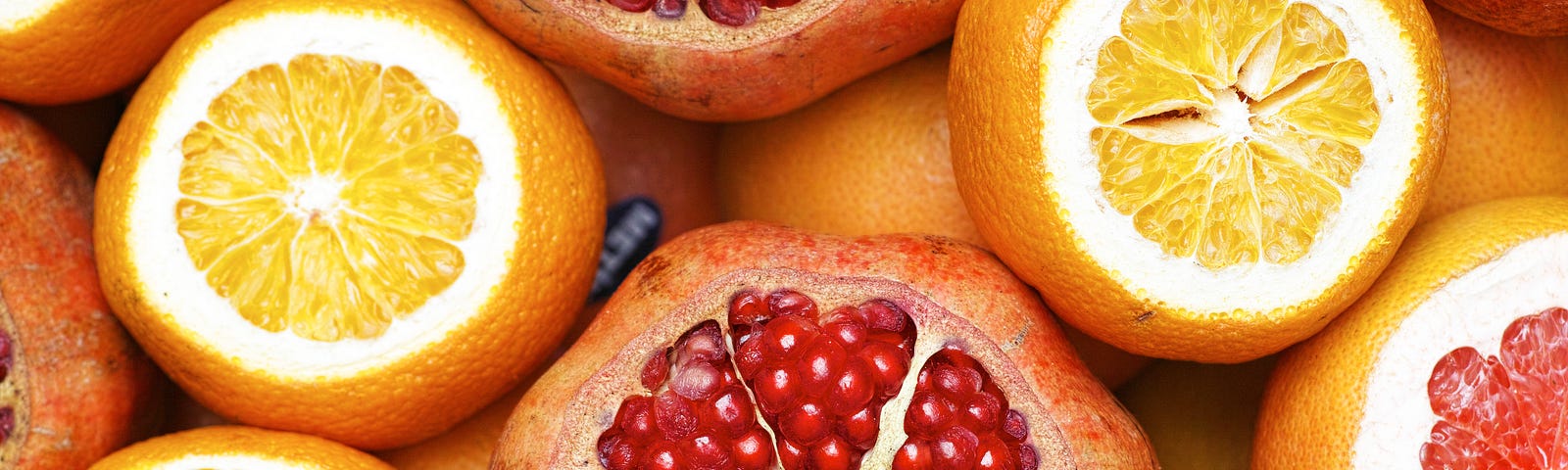 Sliced off citrus fruits — oranges and pomegranates