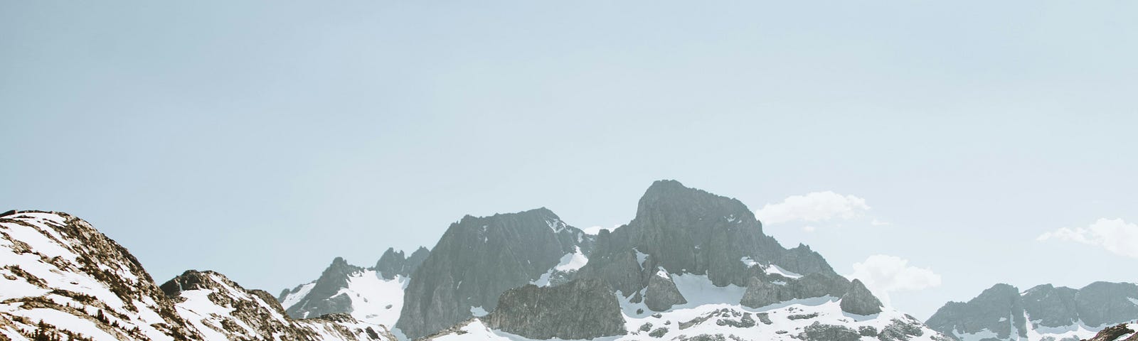 A snow-covered mountain peak mirrors itself on a lake which features a ripple effect in the water.