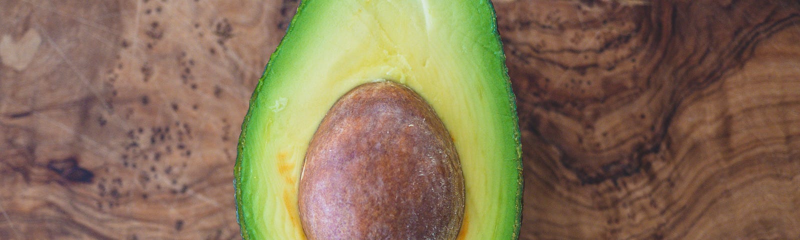 photo of half of an avocado with the pit still in the center