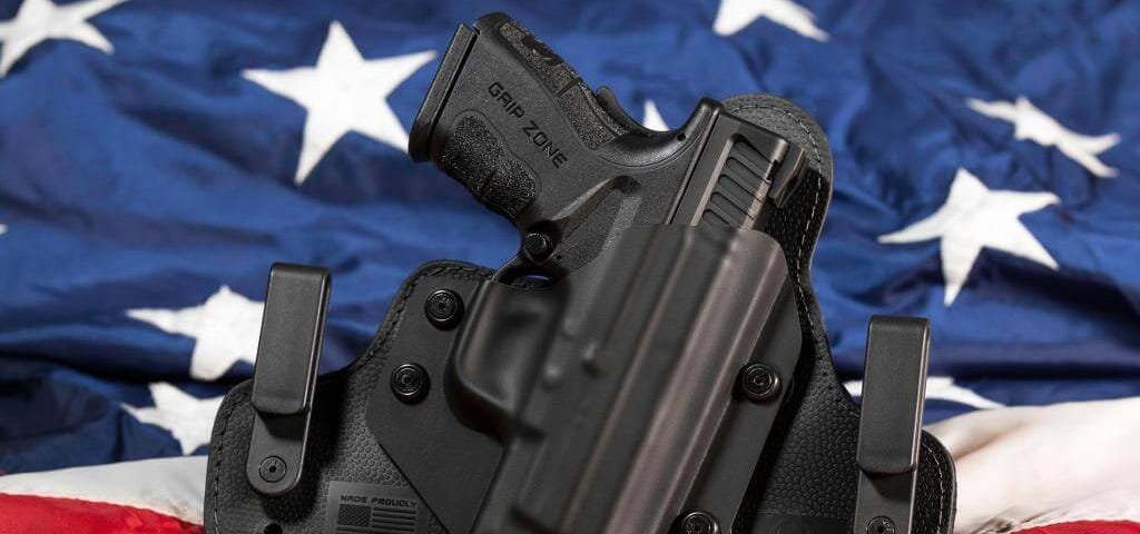 A handgun in a holster on top of an American flag