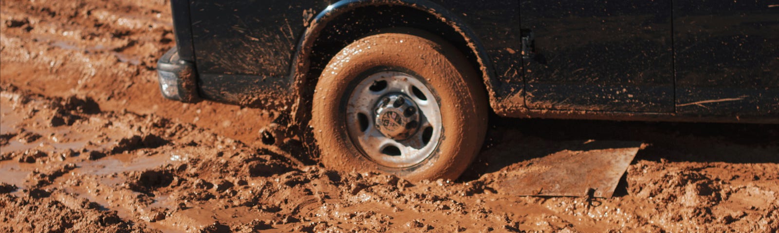 Black Van stuck in red clay