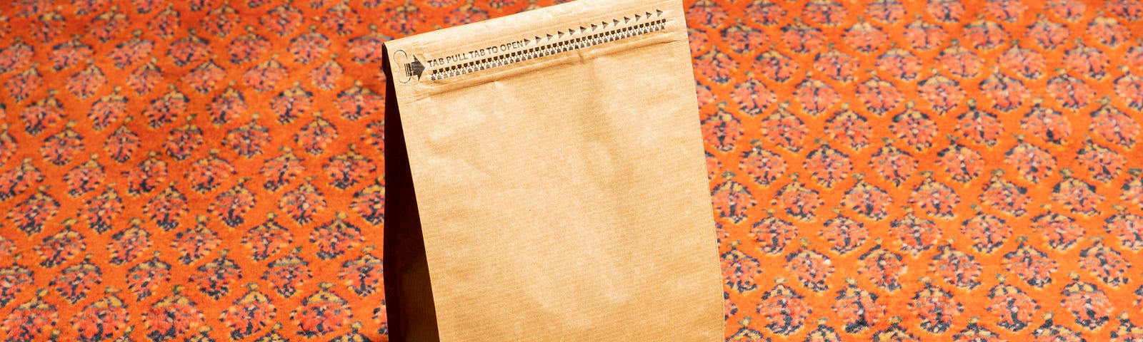 A brown paper sack sitting on a decorative surface