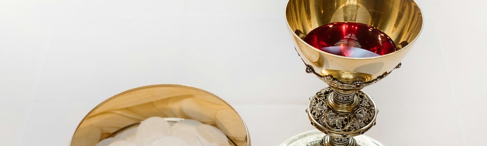 Photo of a silver goblet and wafer bowl used in religious ceremonies.