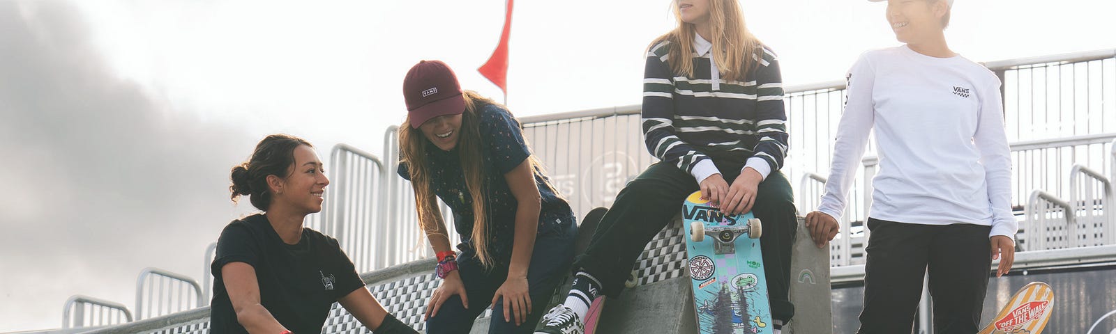 A group of teenagers standing at a skatepark.