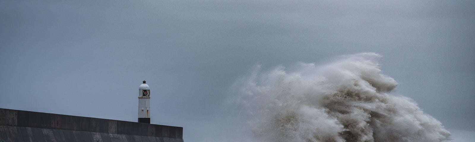 A storm battering  the sea wall and Porthcaw lighthouse