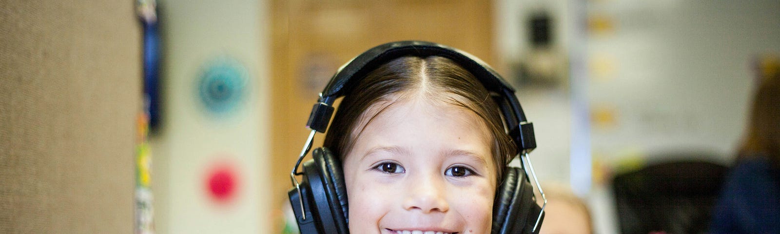 Image of a you g girl at school, wearing headphones