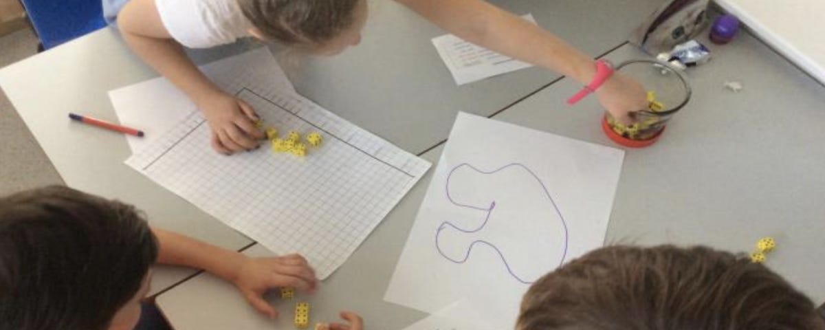 Children graphing out data points at a school work table