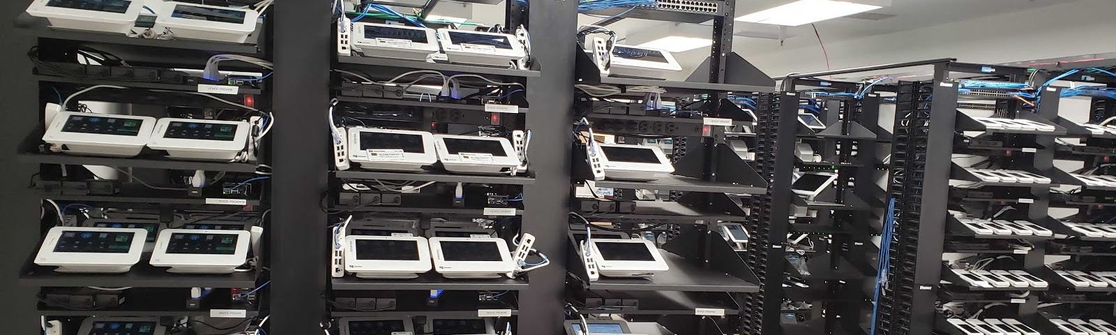 Shelves filled with Clover Mini Point-of-Sale devices for testing.