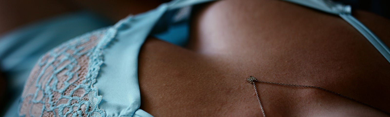 A woman’s breasts in light blue lingerie.