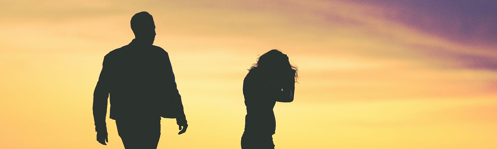 silhouette of couple on the beach, arguing
