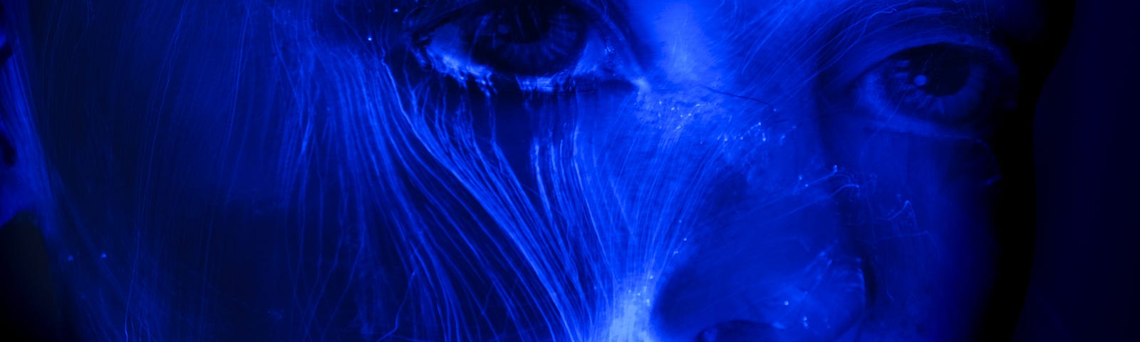 Mystical looking face of a woman blue and glowing with lighter glowing lines on a black background prudence louise Medium