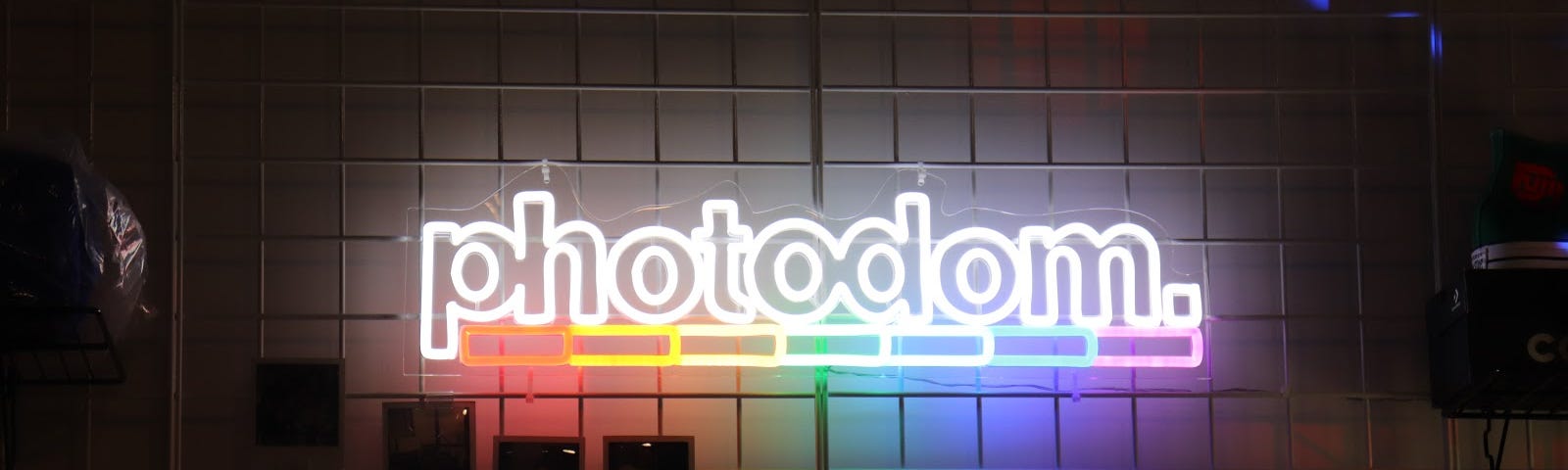 A rainbow-colored neon signage of the Photodom logo